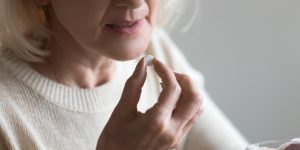Senior adult woman taking medication tablet